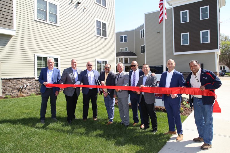 Bristol County Savings Bank employees unveil the new commercial mixed-use property located at 479 West Avenue in Pawtucket, RI by cutting a red ribbon.